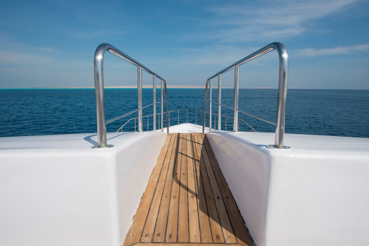 View over the bow of a large luxury motor yacht on tropical open ocean