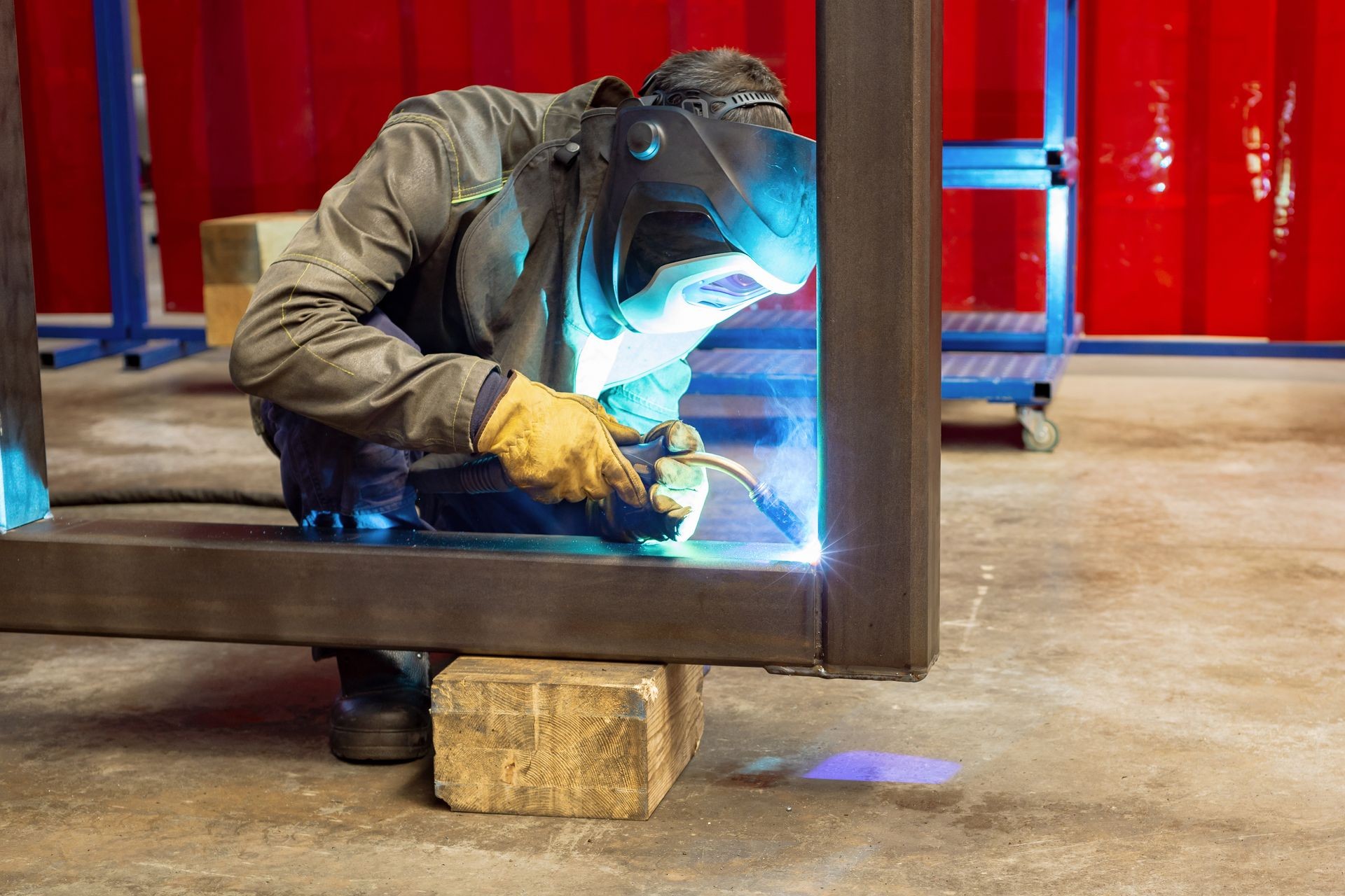 Working welder welds the parts. A process using a semi-automatic welding.
